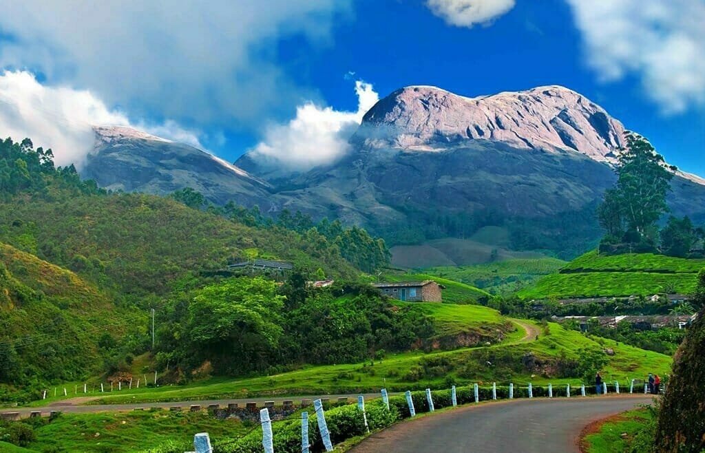 A breathtaking view of Devikulam Hills in Munnar, Kerala, surrounded by lush greenery.