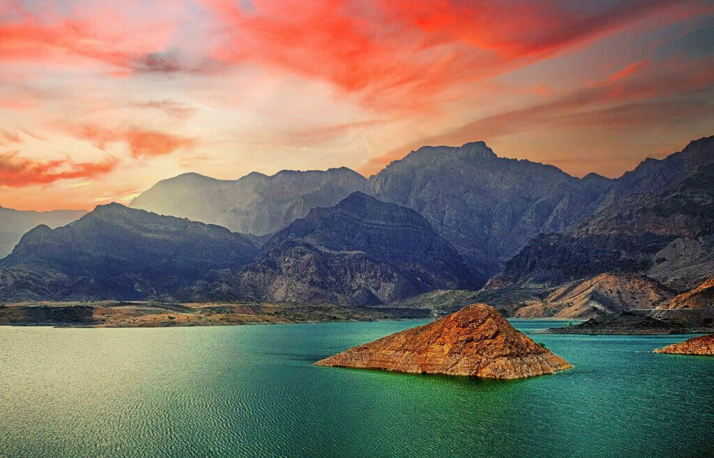 Aerial view of Wadi Ad Dayqah Dam surrounded by rugged mountains and a serene reservoir.