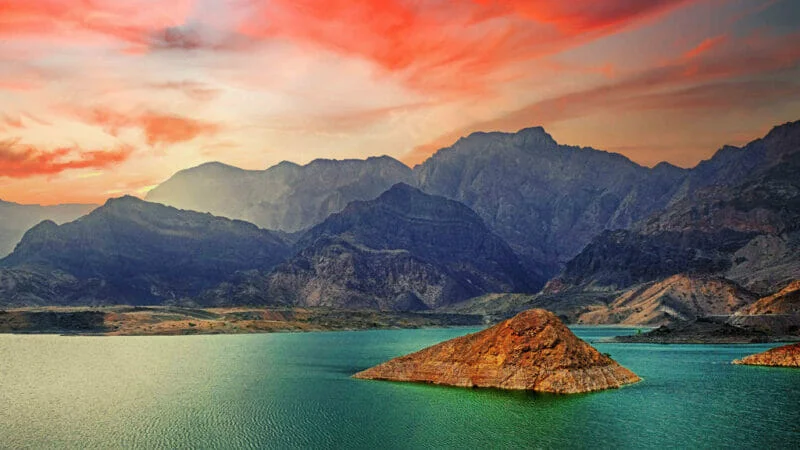 Aerial view of Wadi Ad Dayqah Dam surrounded by rugged mountains and a serene reservoir.