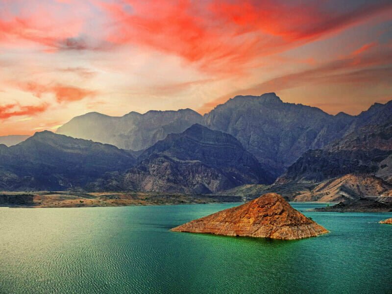 Aerial view of Wadi Ad Dayqah Dam surrounded by rugged mountains and a serene reservoir.
