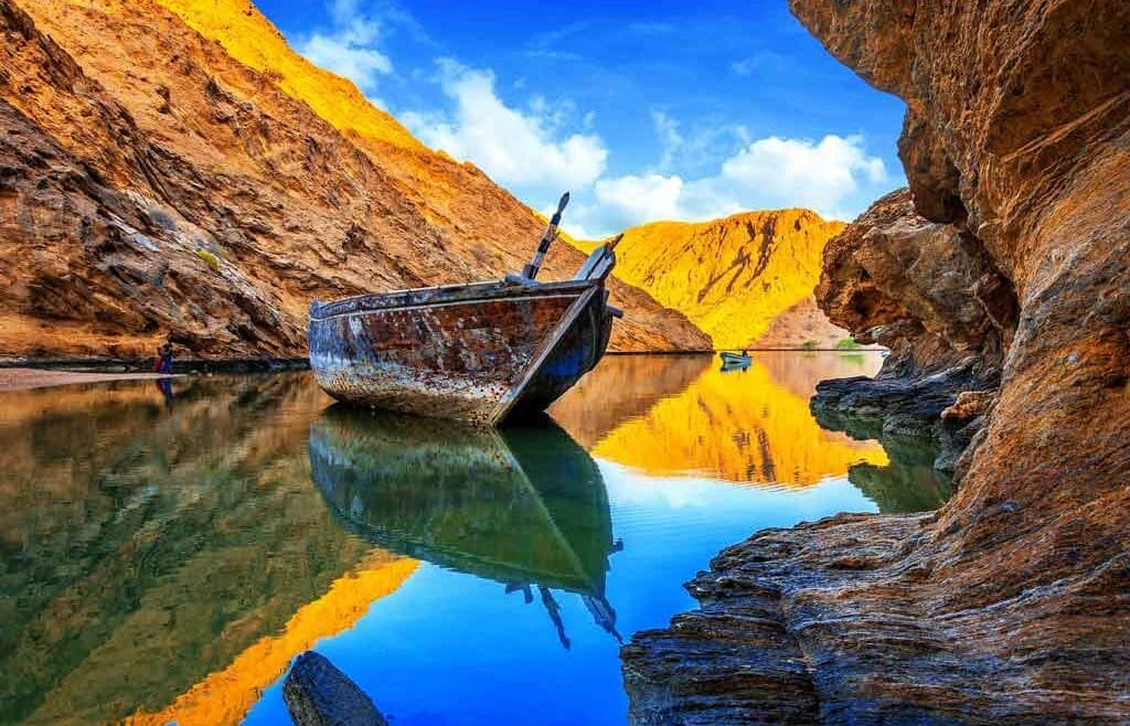View of Bandar Al Khairan Island with turquoise waters and rocky coastline.