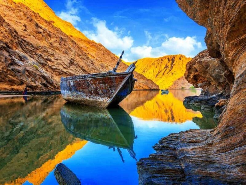 View of Bandar Al Khairan Island with turquoise waters and rocky coastline.