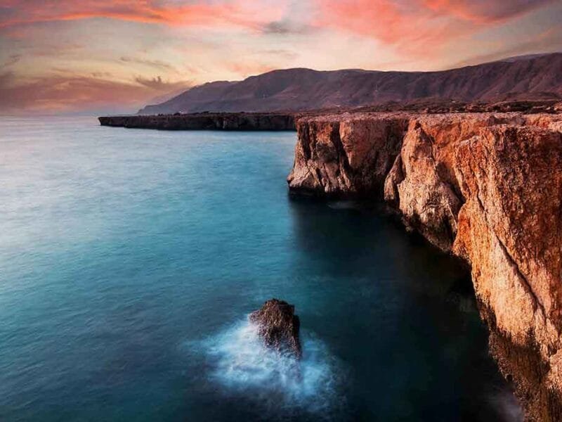 A tranquil stretch of Tiwi Beach, where azure waters meet rugged coastline.